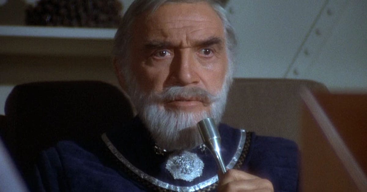 A screen capture of Lorne Greene playing Adama whist wearing a beard.