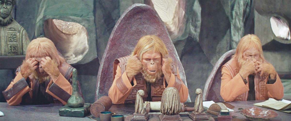 A screen capture from the film "Planet of the Apes" showing three apes.