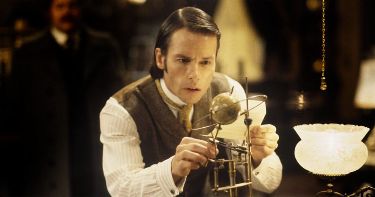 A film still showing Guy Pearce looking at a globe.