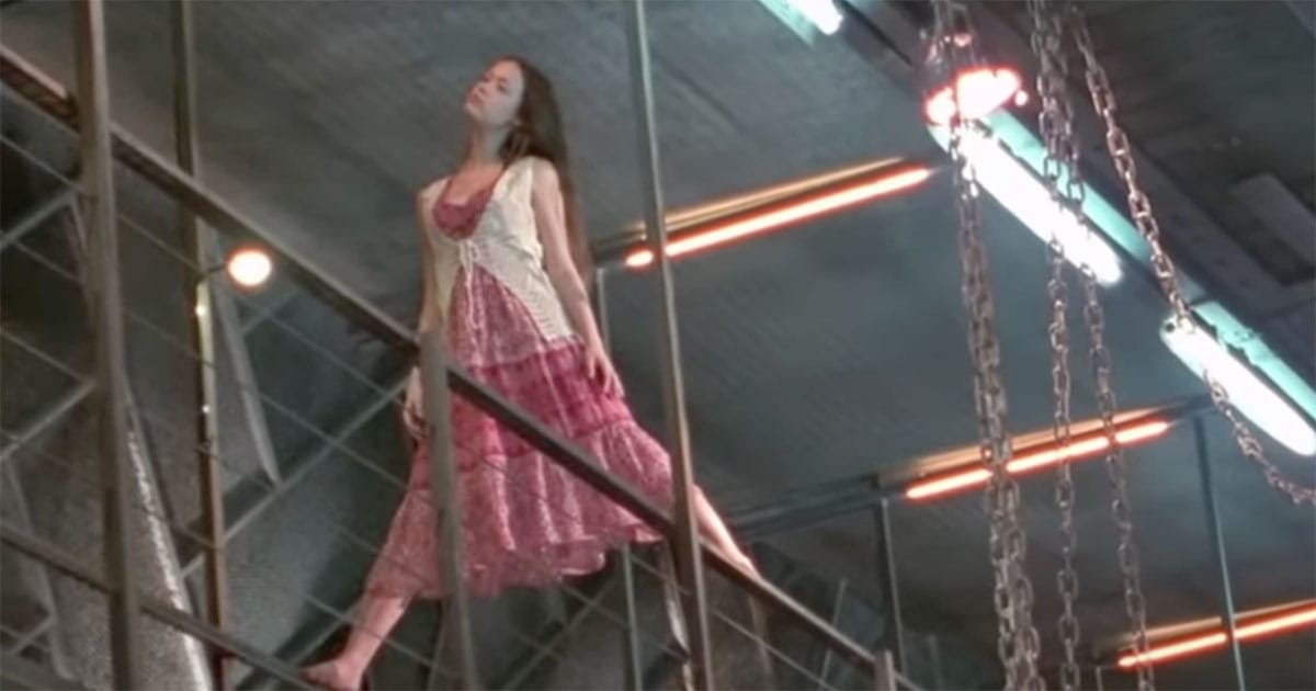 Screen capture of River standing on the railing on the spaceship Firefly.