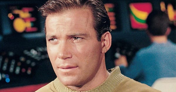 William Shatner as Captain Kirk, wearing a gold Starfleet uniform, looking determined on the bridge of the Enterprise.